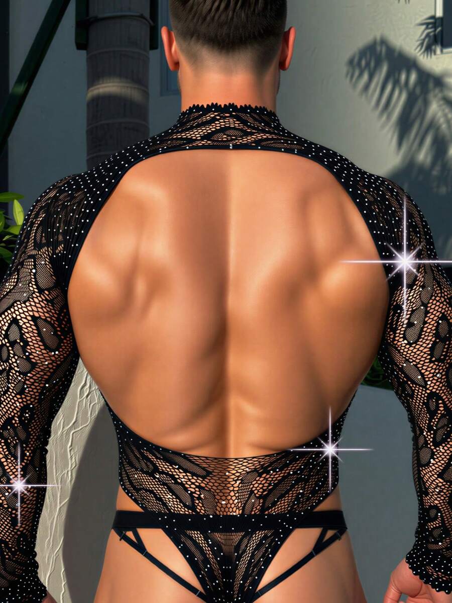 A man wearing a black hollow out rhinestone long jumpsuit featuring a stand collar and sheer knitted fabric.