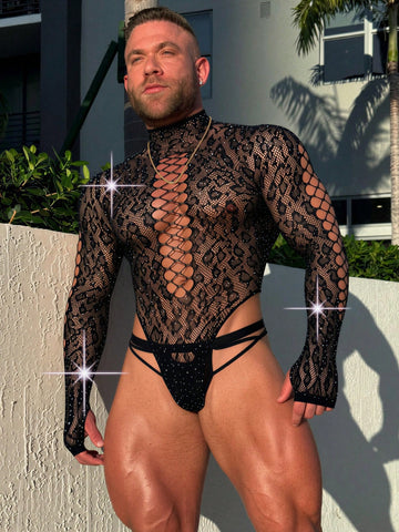 A man wearing a black hollow out rhinestone long jumpsuit featuring a stand collar and sheer knitted fabric.