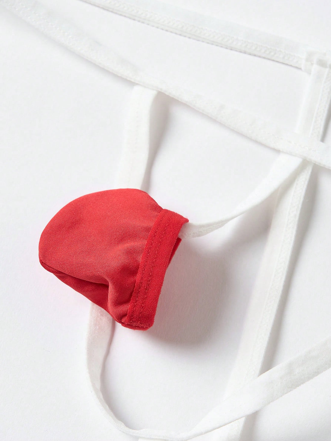 Front view of men's red and white low-rise thong underwear featuring a plain pattern and knitted stretch fabric.